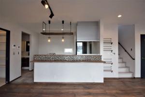 大人な落ち着き感のある、カフェスタイルのキッチン。カウンターに使われたタイルにもこだわりのカラー。階段横にマガジンラック！